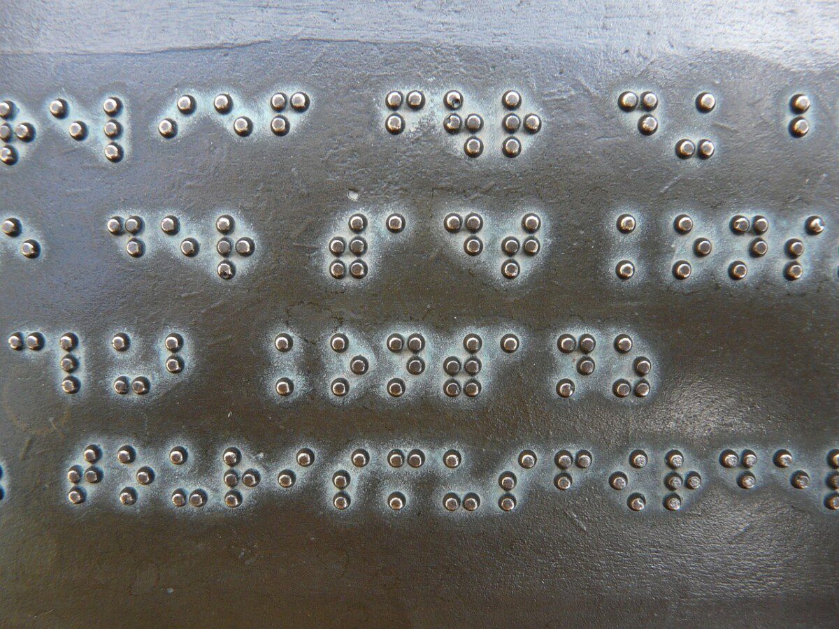 Das Foto zeigt eine Bronzetafel mit der Blindenschrift: Brailleschrift