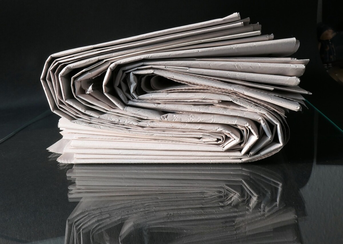 Auf dem Foto sieht man einen Stapel Zeitungen. Der symbolisch für die Pressearbeit und Pressetexte steht.