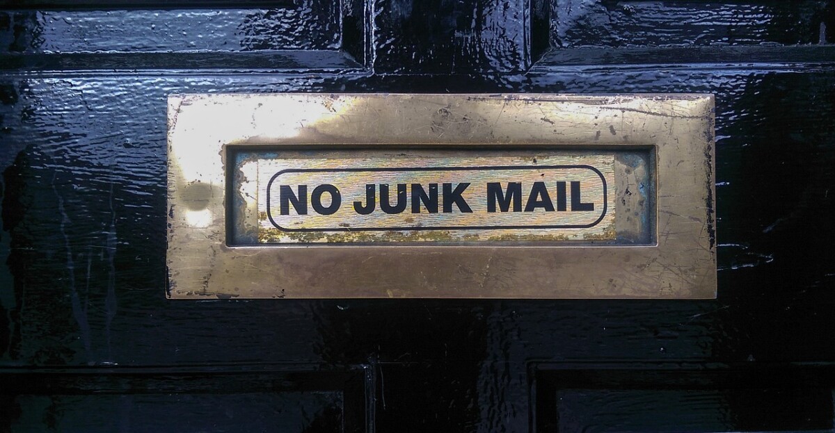 Auf dem Bild ist ein Türschild zu sehen, auf dem "No Junk Mail" steht.